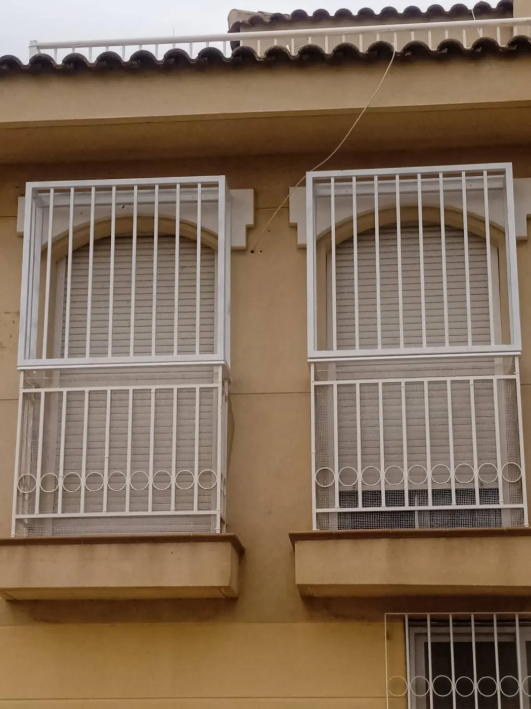 Rejas metálicas blancas en ventanas